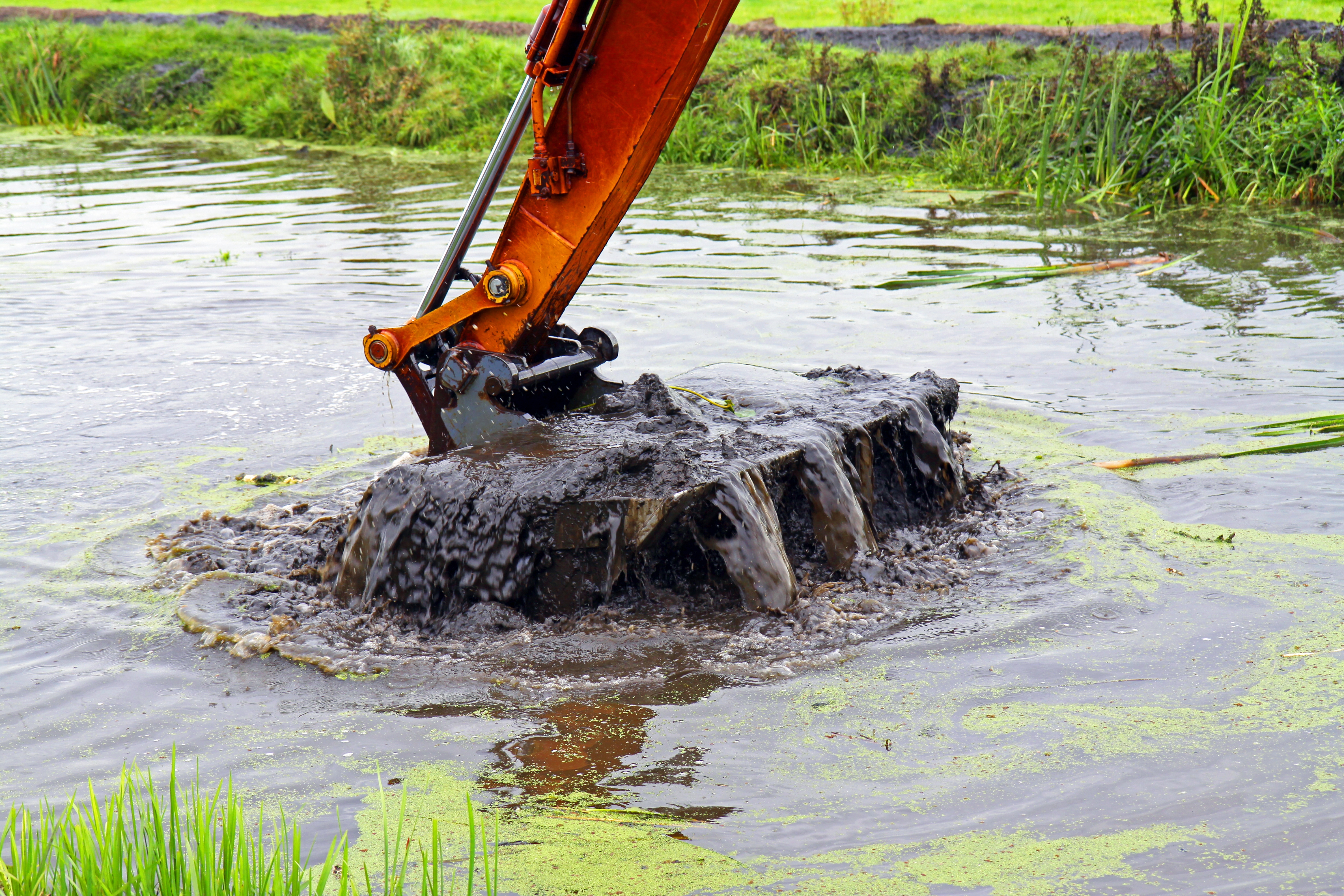 Sediment wird aus einem Teich gebaggert  